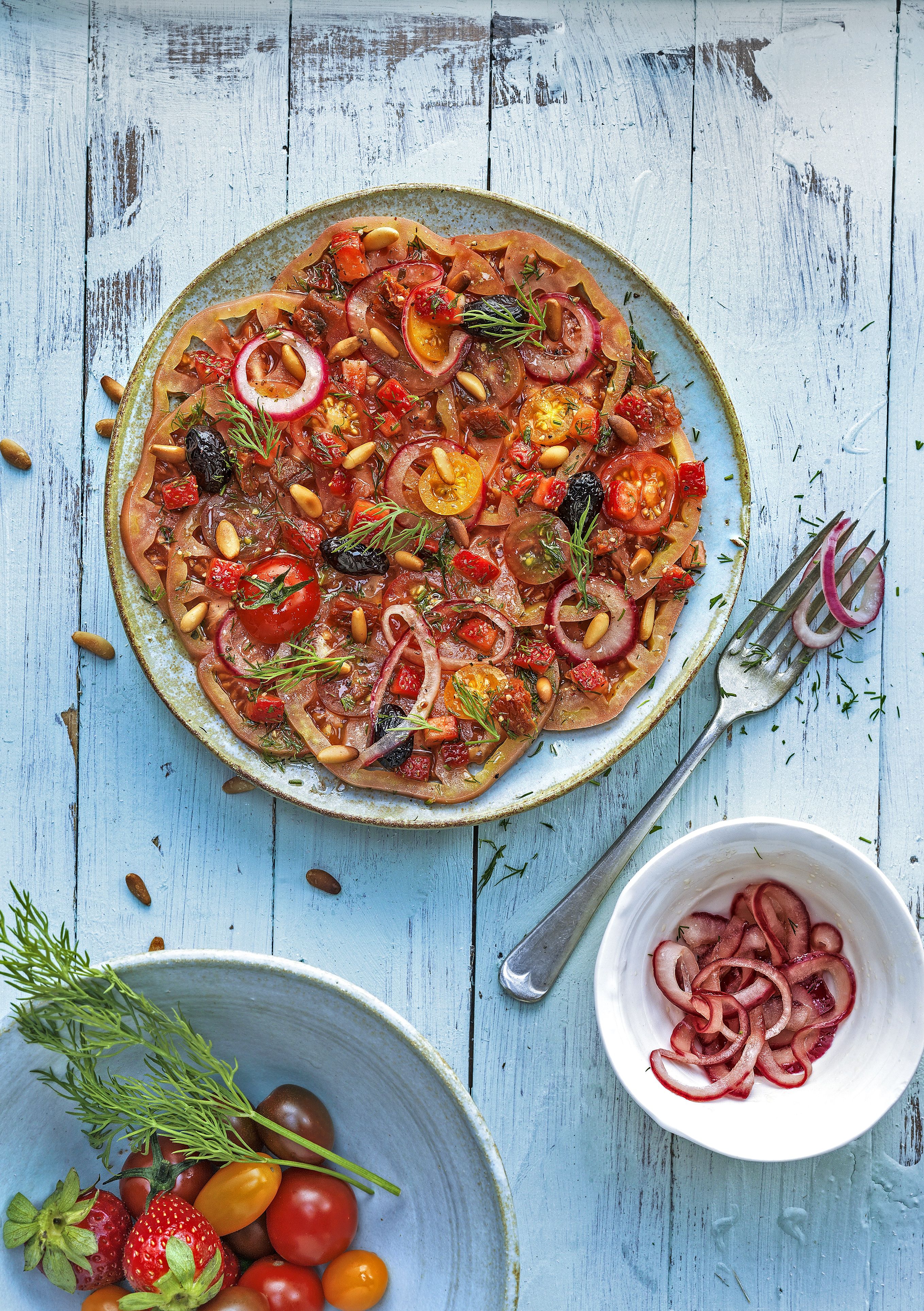 Carpaccio de tomàquets, maduixes, anet i olives negres
