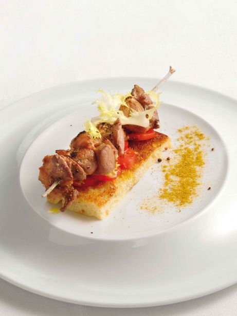 Brocheta de cordero marinat sobre 'focaccia' de romero y escarola