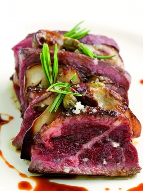 Chuletón de buey fileteado con romero, setas y pimienta verde