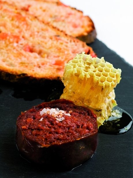 Pan de olivas con tomate, sobrasada y bresca de miel