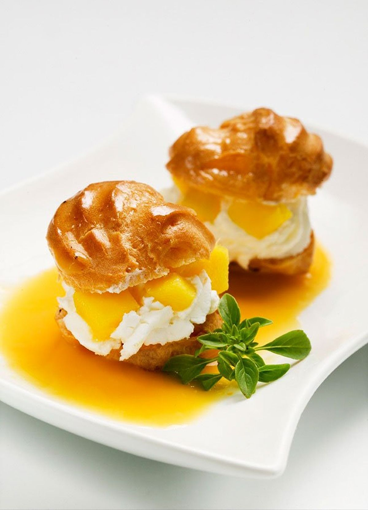 Lioneses de nata amb mango i almívar d'alfàbrega