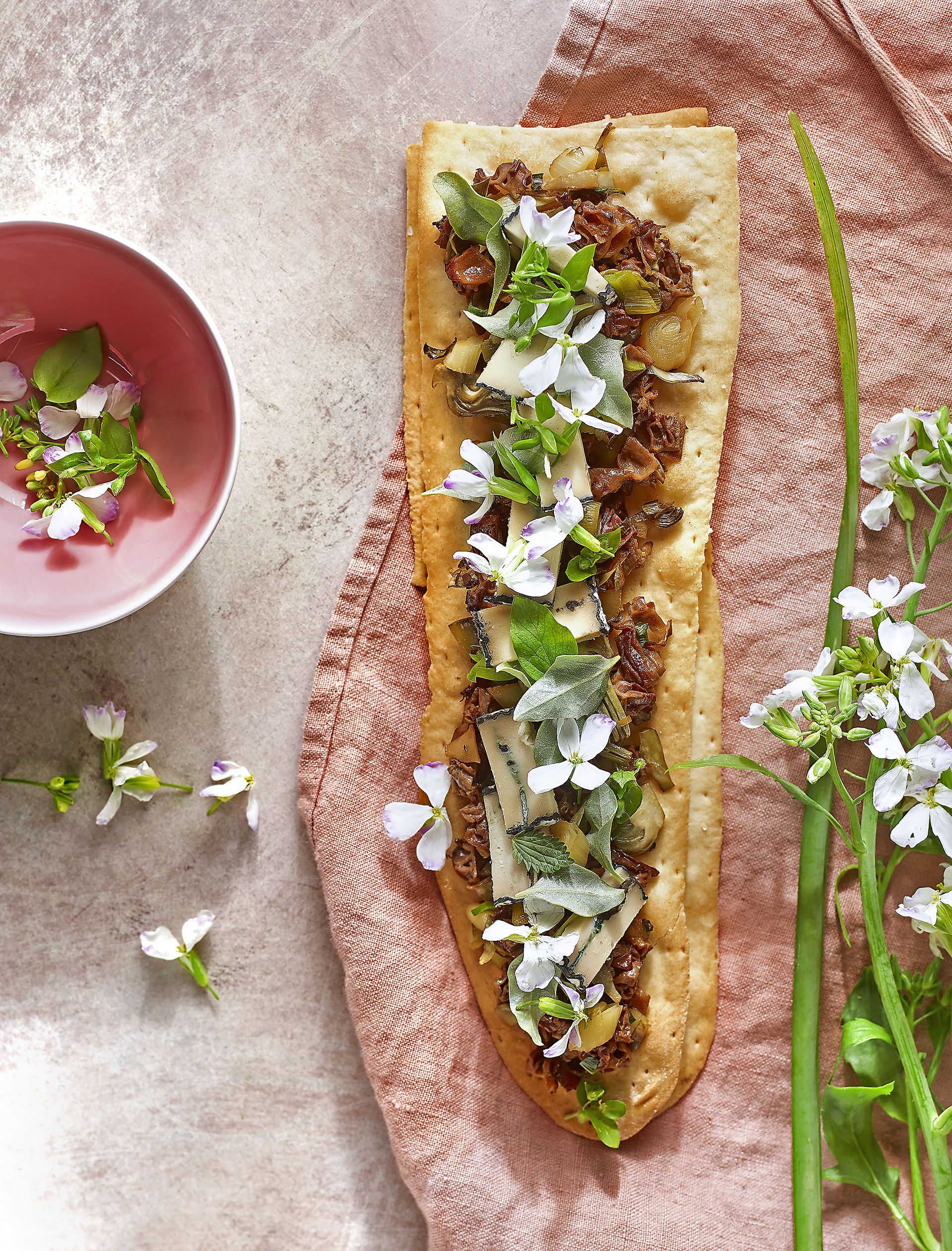 Coca amb saltat de primavera i formatge blau d'anacards
