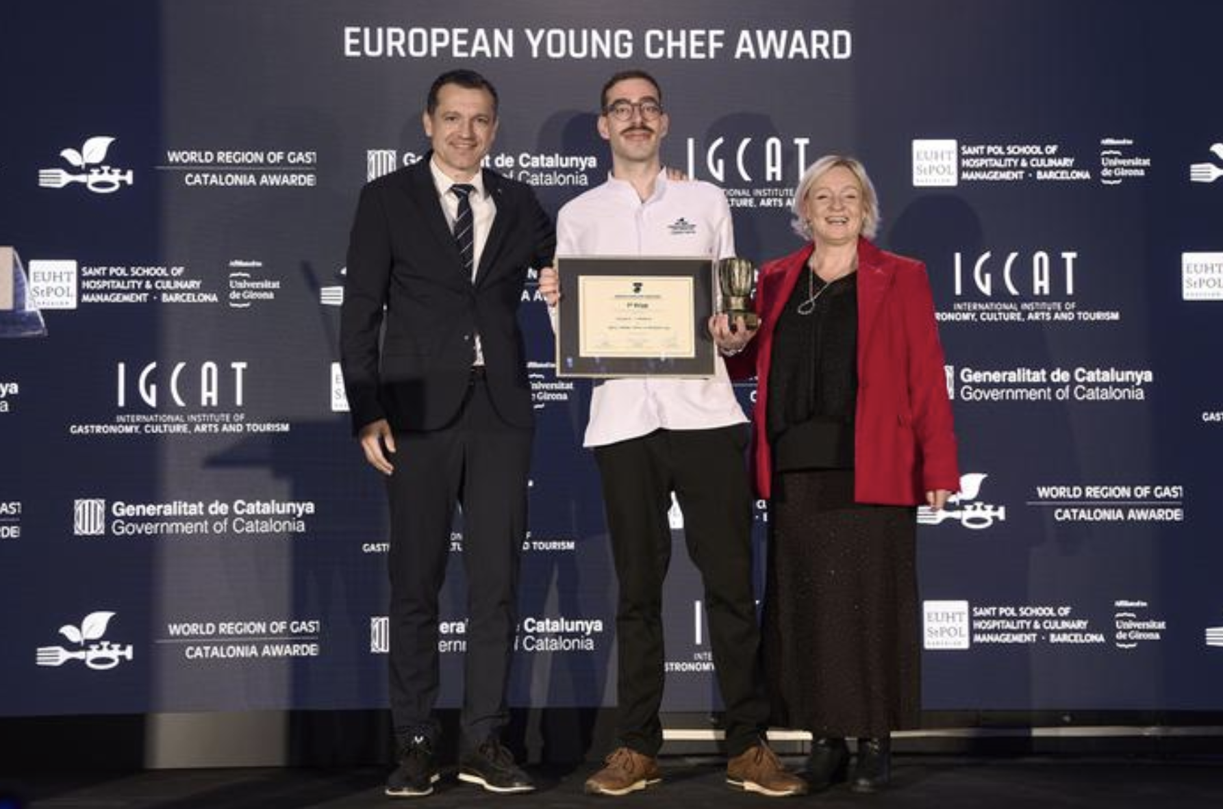 El conseller Ordeig y la presidenta de IGCAT, Diane Dodd, con Ioannis Liapakis, representante de Creta y ganador del concurso European Young Chef 2025