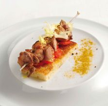 Brocheta de cordero marinat sobre 'focaccia' de romero y escarola