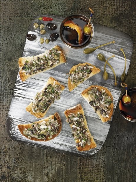 Tostadas con picadura de anchoas, alcaparras, cebolla, perejil y guindilla