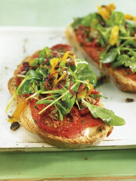 Mini pizza de tomates secos, rúcula y pasas