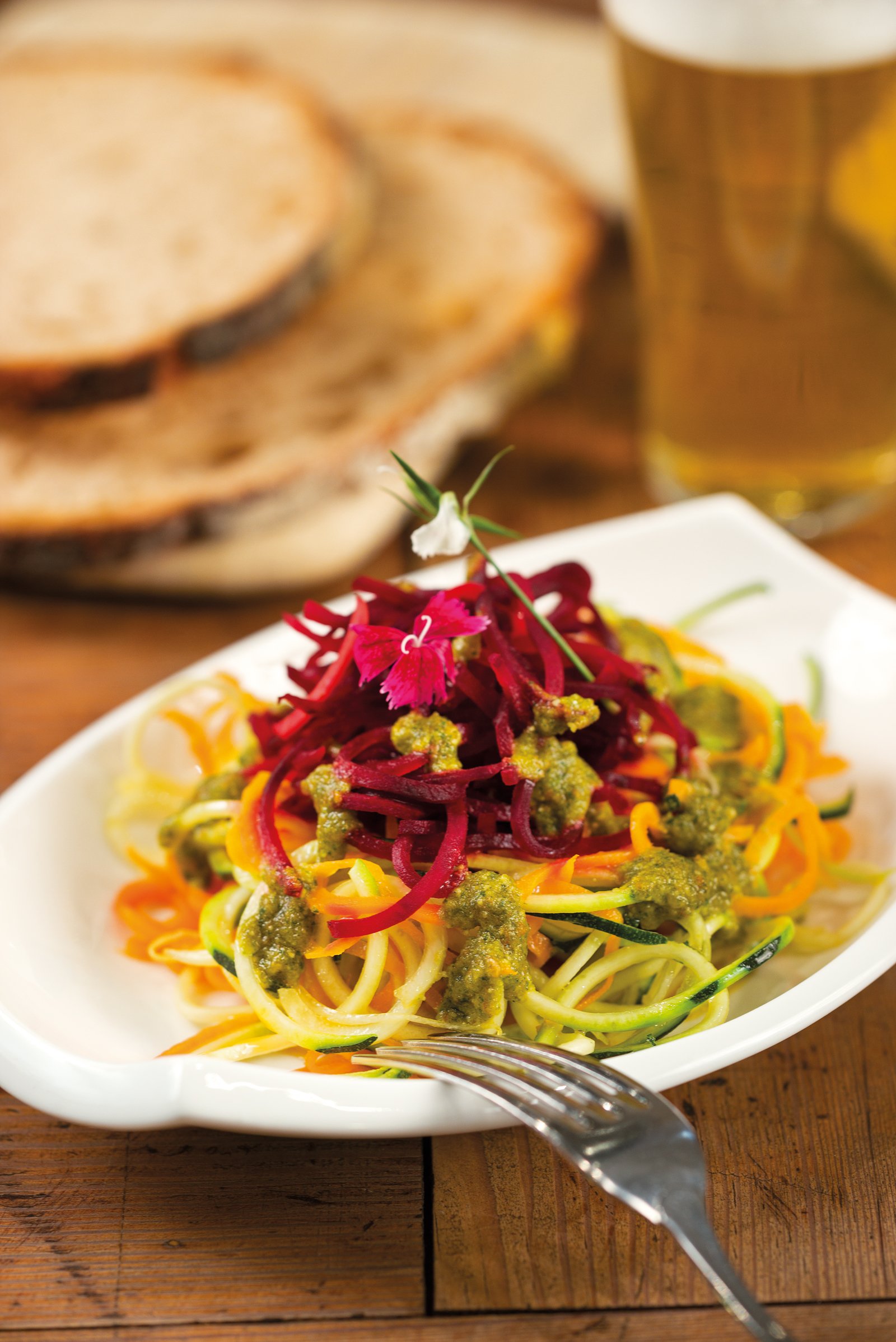 'Zoodles' de carbassó, pastanaga i remolatxa amb pesto de ruca i tomàquets secs