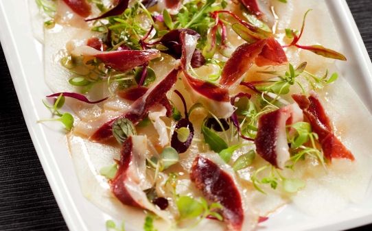 Carpaccio de meló amb vinagreta de mel i pernil d'ànec