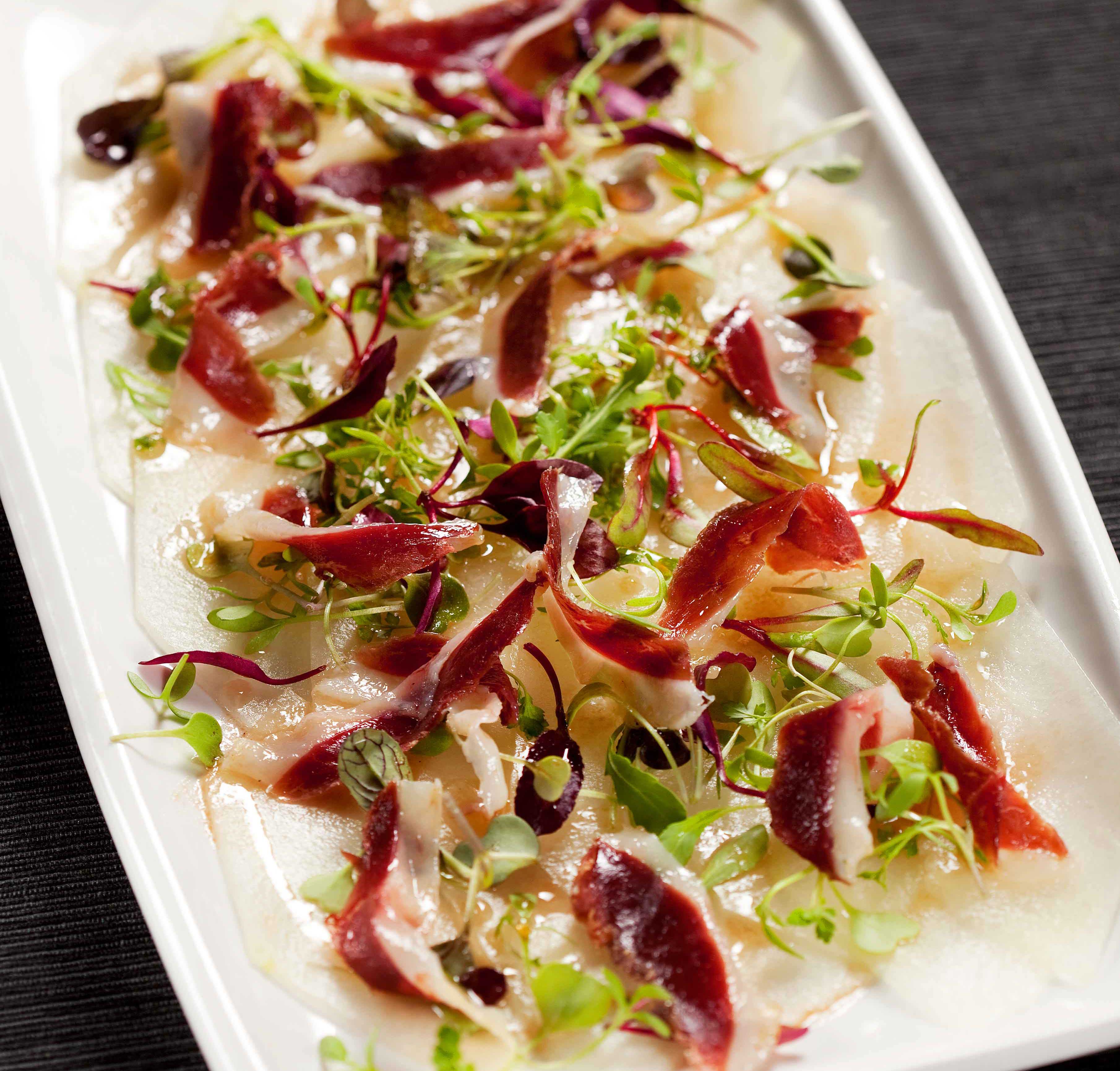 Carpaccio de meló amb vinagreta de mel i pernil d'ànec