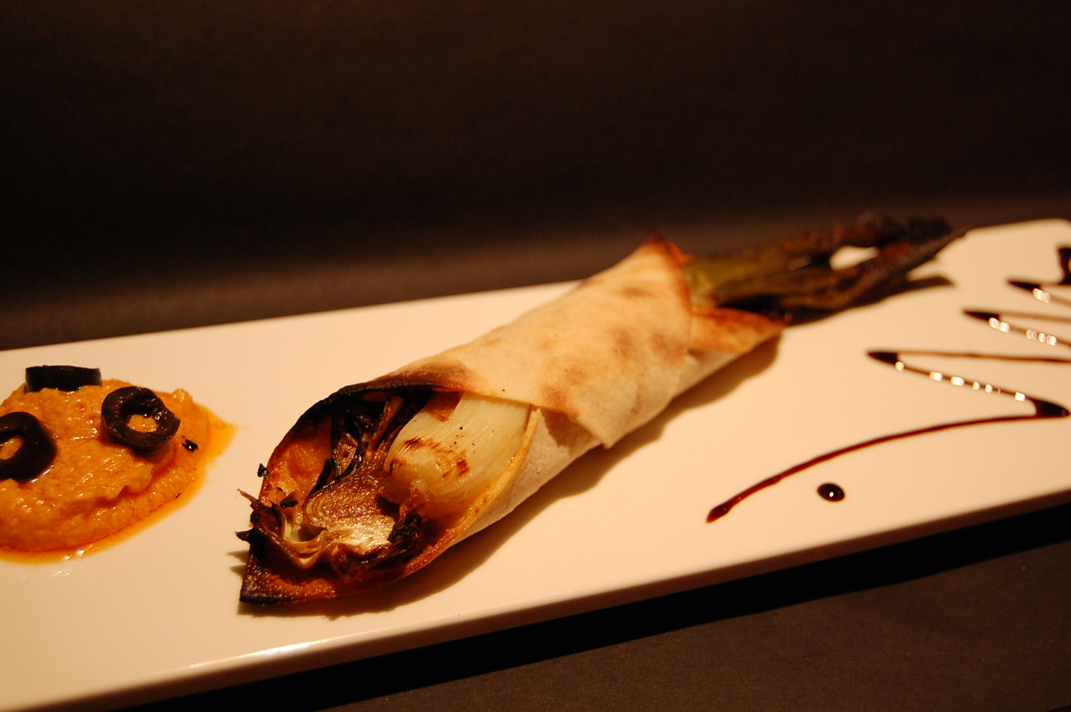 Pizza enrotllada farcida de calçot, romesco, emmental i carxofa