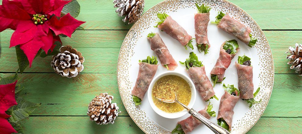 Tapes de carpaccio amb ruca, panses i vinagreta d'oli d'oliva verge extra i mostassa